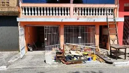 Imóvel da primeira loja antes da reforma, com material de obra na calçada
